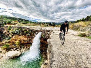 Mountain biker near Salt de la Portellada waterfall Matarraña Spain
